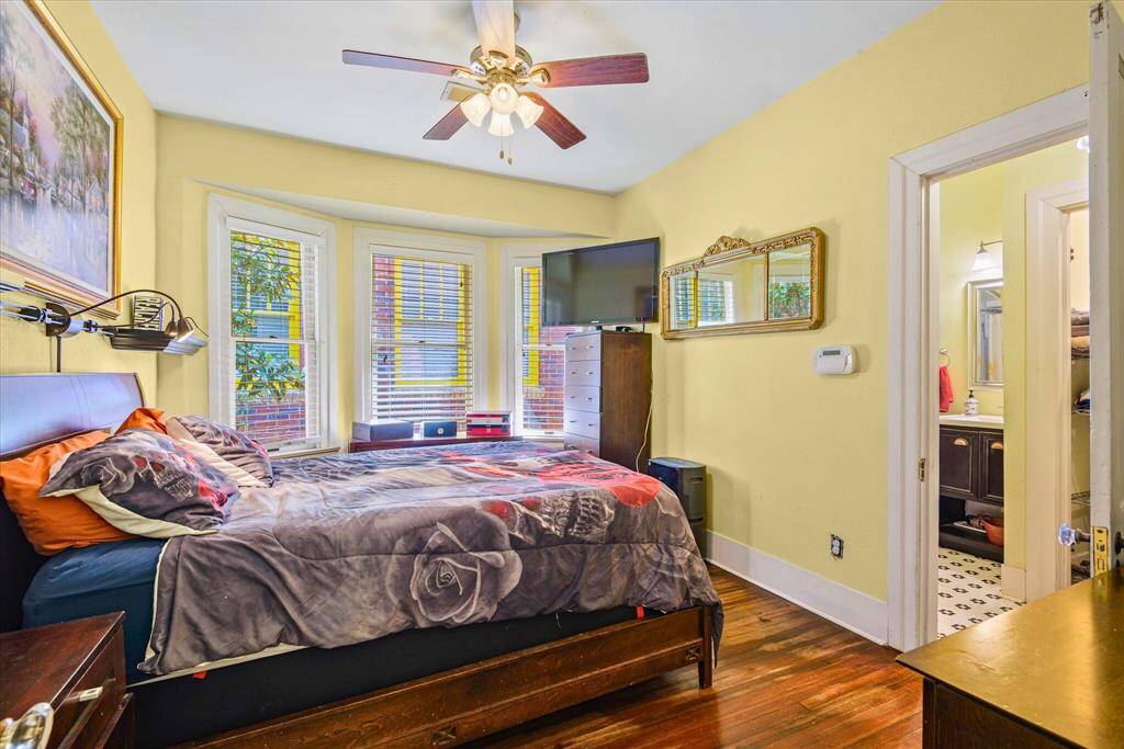 This charming Primary Bedroom features warm hardwood floors and beautiful bay windows providing ample natural light