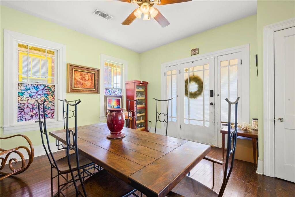 This Dining Room features hardwood floors, and two stained glass windows to provide natural light