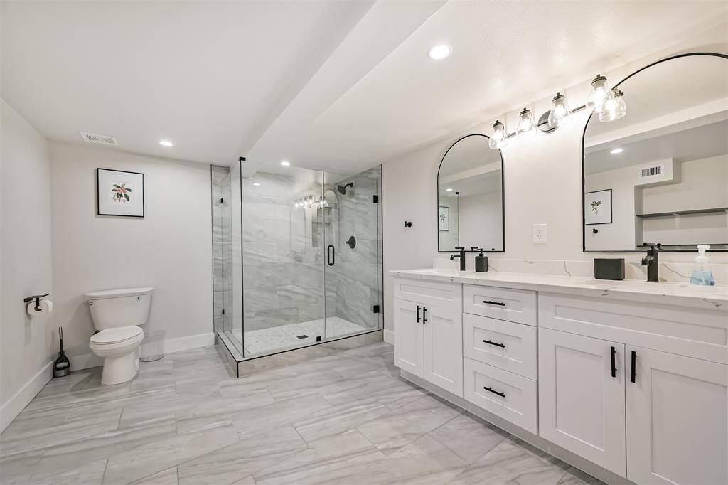 Large primary bath with a large walk-in shower and his and hers sinks with plenty of room for a soaker tub.