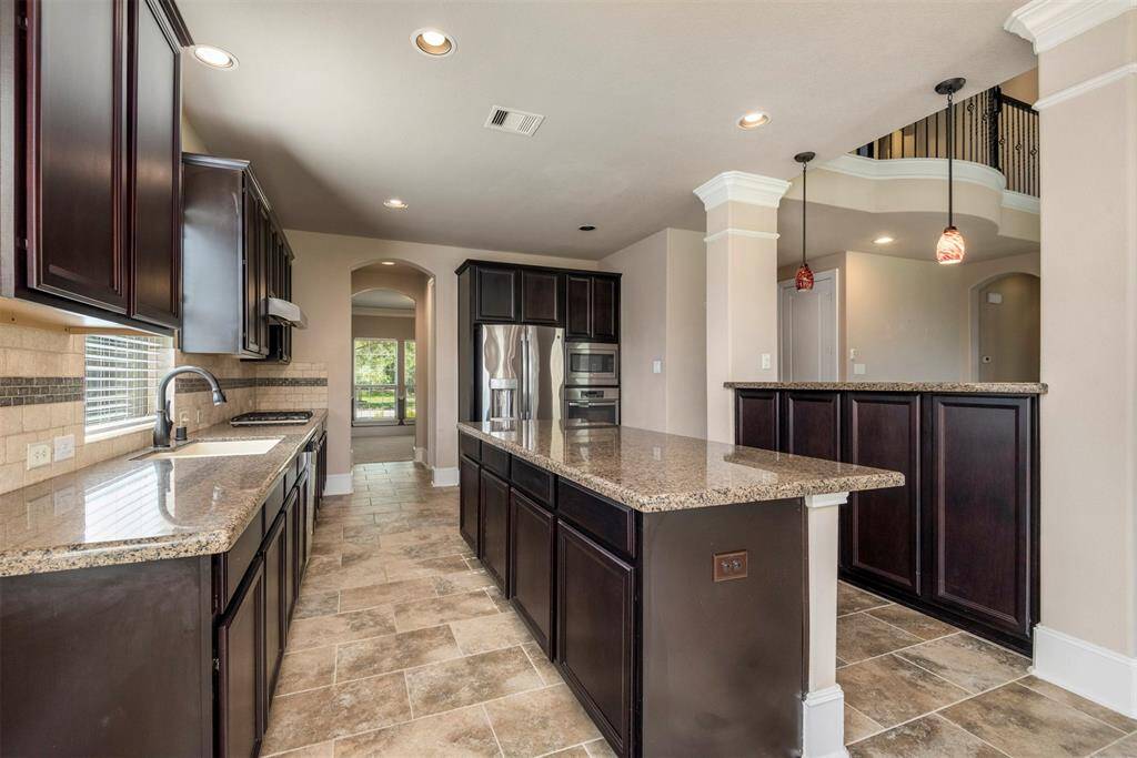 Warm and inviting island kitchen with stainless appliances and tons of storage and counter space. Fridge included.