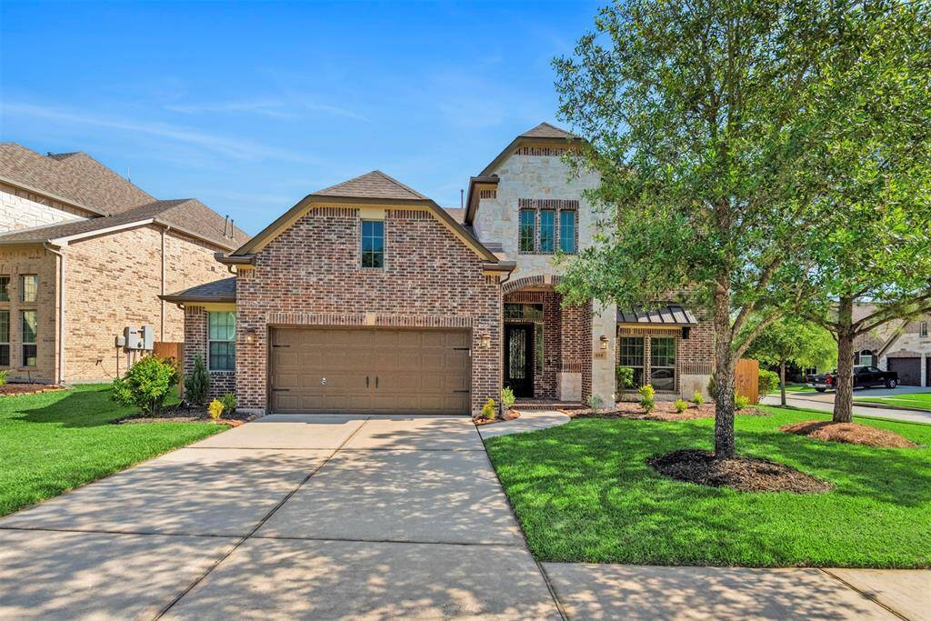 Gorgeous elevation with brick and stone, mature trees and OVERSIZED 2 CAR GARAGE.