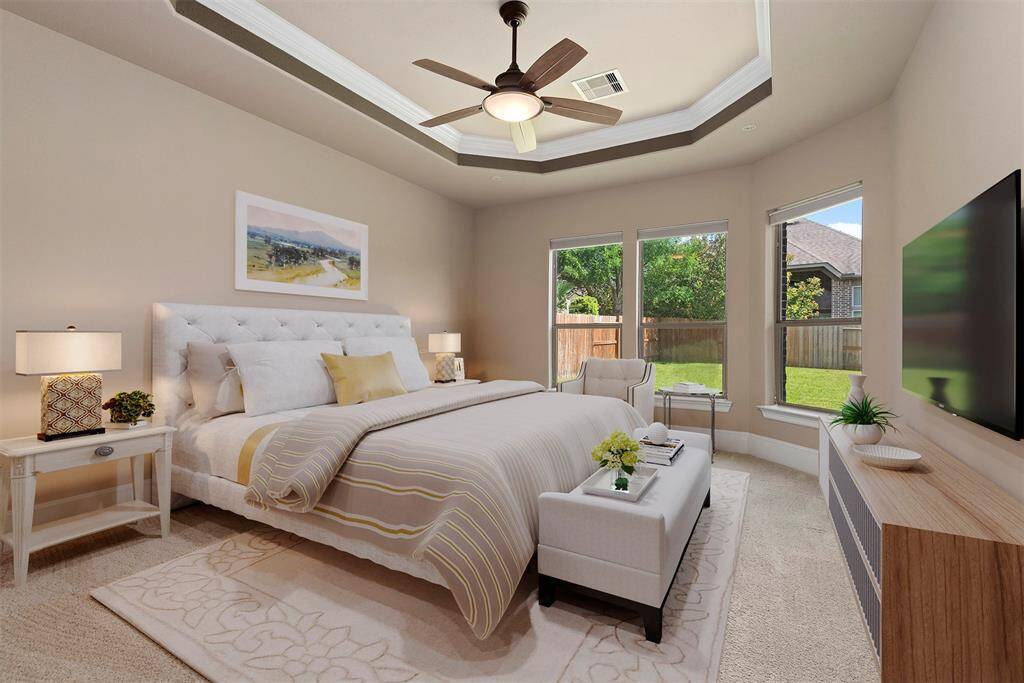 Virtually staged primary bedroom with tray ceiling and wall of windows.