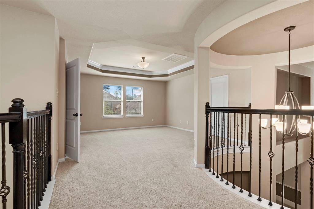 Game room upstairs with tray ceiling.