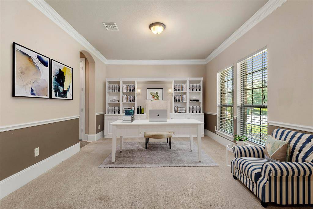 Flex room with crown molding at the front of the home staged as a study. This room is full of sunlight and would make the perfect home office. Plenty of room for multiple work stations. Virtually staged.