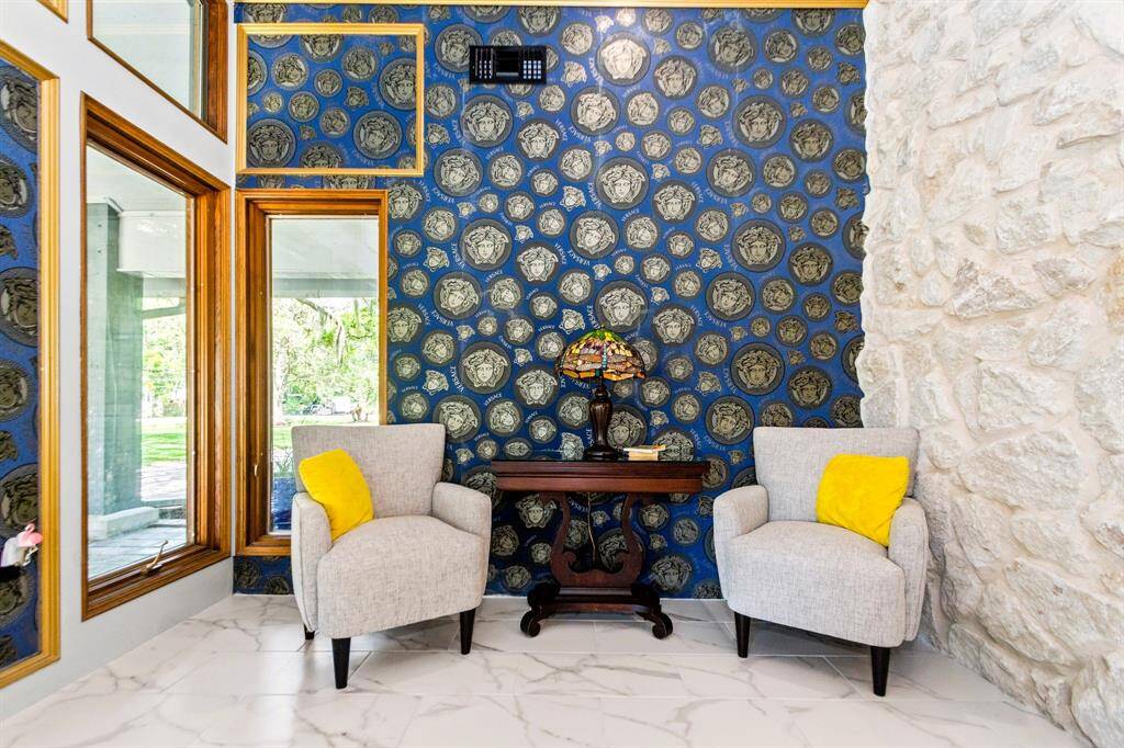 The foyer features elegant stone flooring and luxurious Versace wallpaper, creating a stunning first impression.