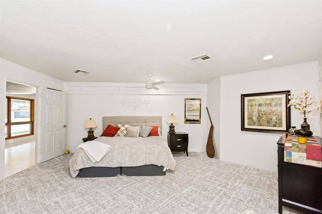 The spacious third bedroom is enhanced with built-in bookshelves and luxurious designer carpeting, creating a stylish and functional retreat.