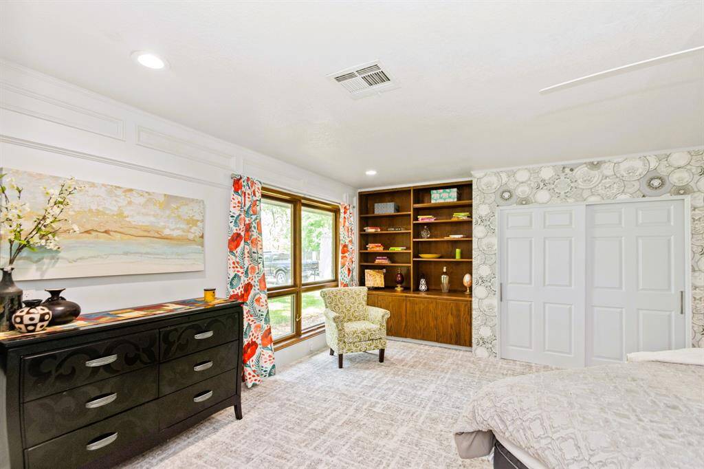 The spacious third bedroom is enhanced with built-in bookshelves and luxurious designer carpeting, creating a stylish and functional retreat.
