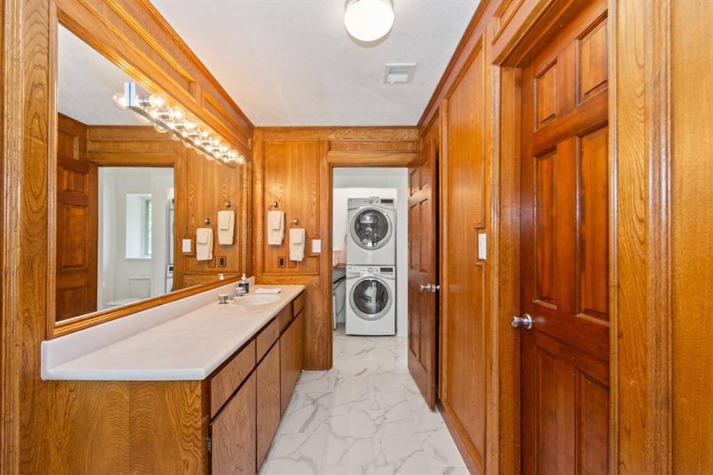 The guest house bathroom is thoughtfully designed, featuring convenient washer and dryer hookups for added functionality.