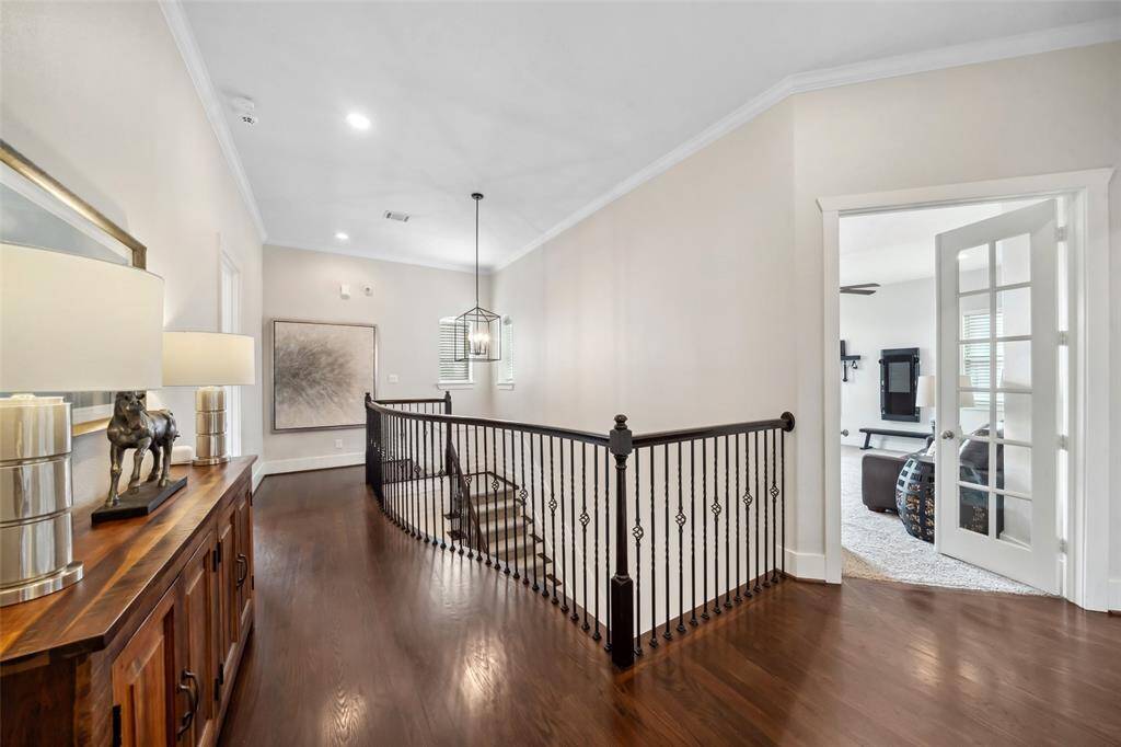 From this angle on the upstairs landing, you can see Secondary Bedroom 1 with its door on the left, while the game room is conveniently located to the right, offering a perfect space for relaxation and entertainment.