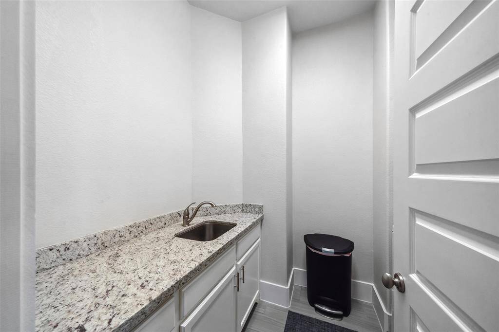 The second-floor laundry room is both functional and stylish, featuring ample cabinetry, granite countertops, and a convenient sink—making laundry a breeze!