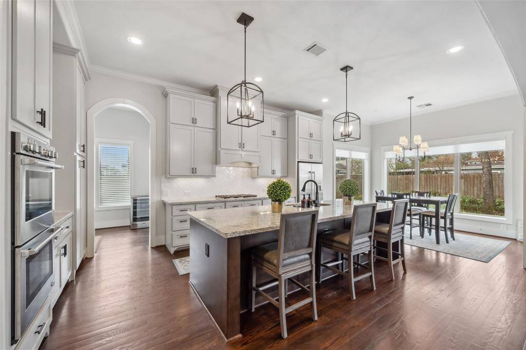 The stunning chef’s kitchen is truly picture-perfect, featuring granite countertops, designer fixtures and hardware, and ample cabinetry and drawers for storage. The warm, updated color scheme enhances the inviting atmosphere, while double ovens and stainless steel appliances, including a refrigerator that conveys, provide both style and functionality for effortless cooking and entertaining.