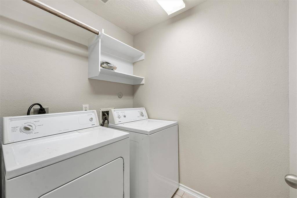 Upstairs laundry room with a washer and dryer conveying with the home.