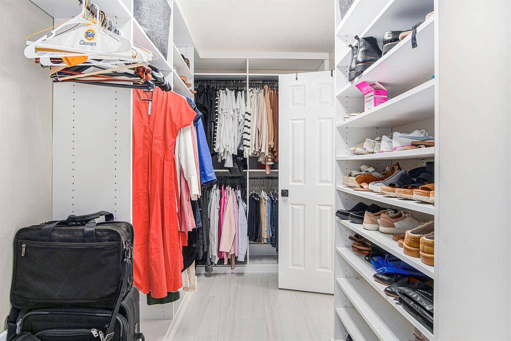Stunning primary closet with built in organization system.