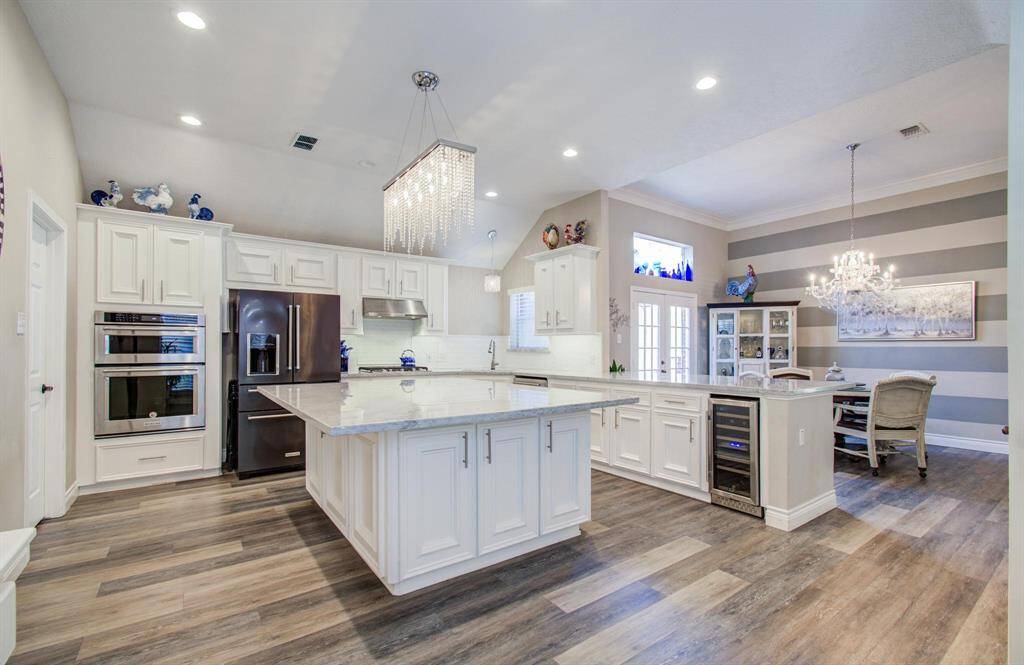 The beautifully designed kitchen is the center piece of the home! The spacious island has storage on all sides and ample seating for bar stools—ideal for casual dining and entertaining. Laundry room and garage entry is thru the door to the left.