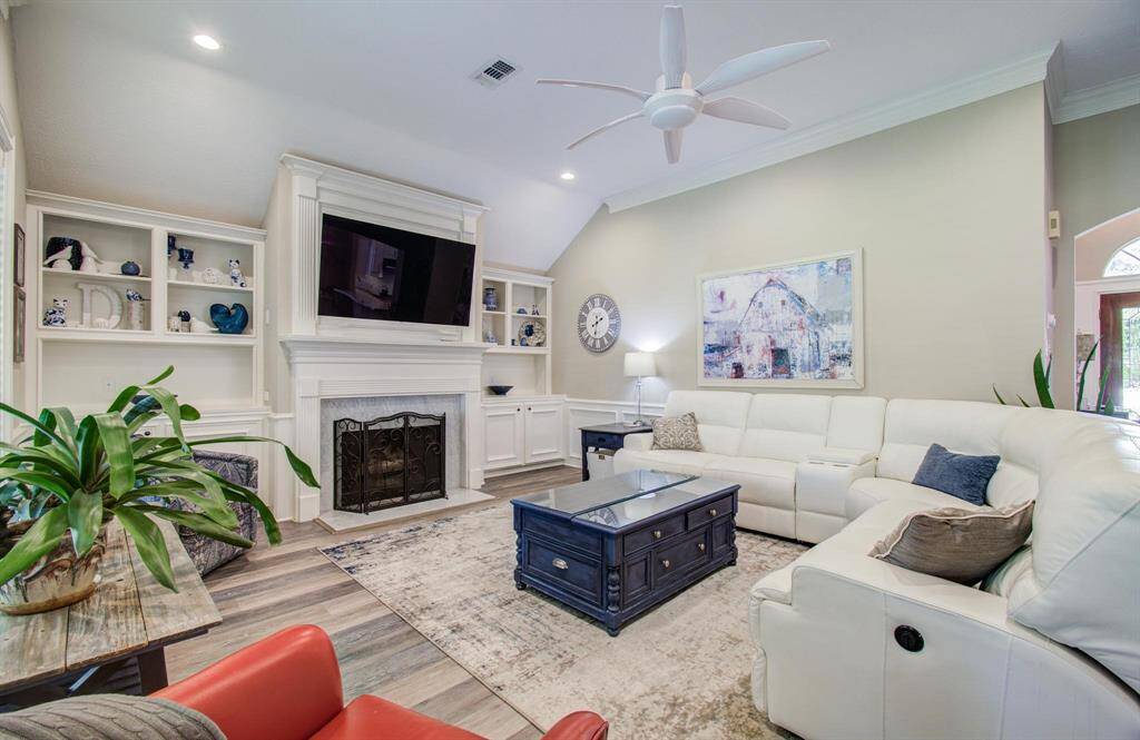 The living room features a gas log fireplace, built-ins and high ceilings!