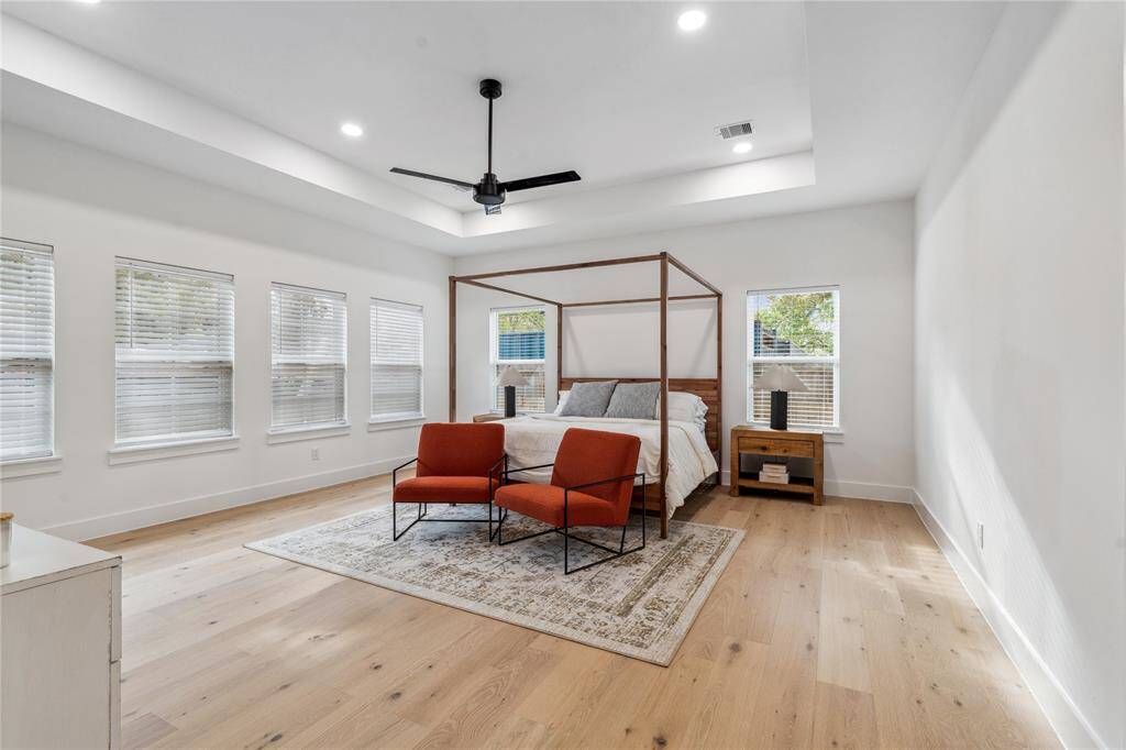 The primary bedroom is a rear fine in a bungalow featuring a spacious bedroom with tray ceiling.