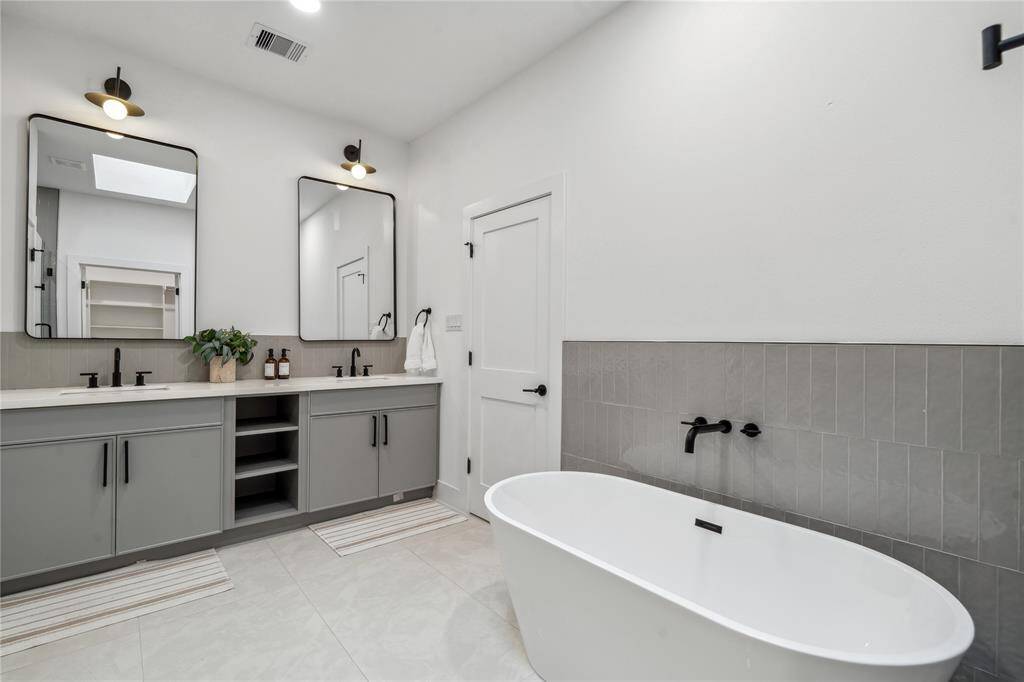 The primary en suite is a stunner with oversize counters, separate vanity mirrors, a standalone tub, along side, design, or vertical tile.