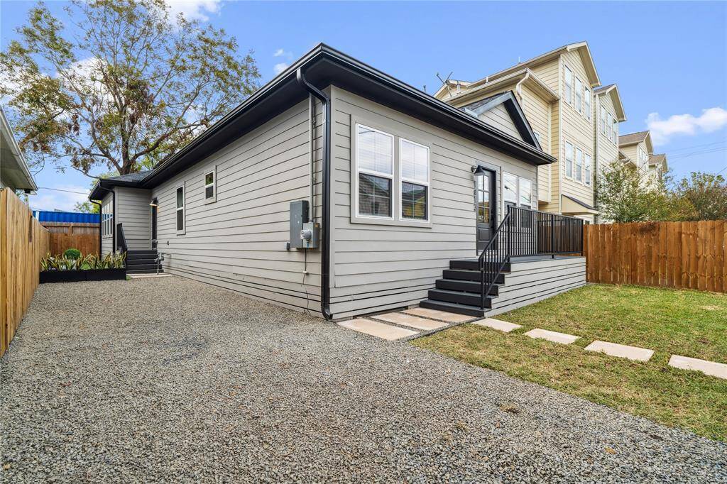 The exterior of the home features flagstone, driveway, a front yard, including a backyard with artificial turf, as well as a front porch.