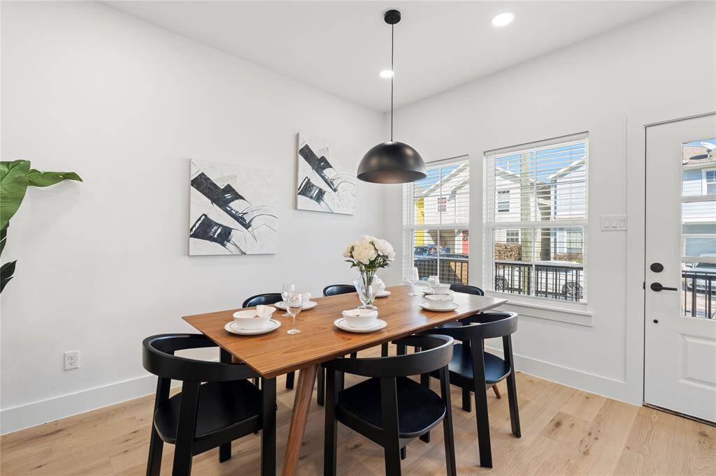 The dining room is nestled alongside natural light and a scenic view of this quiet neighborhood street.