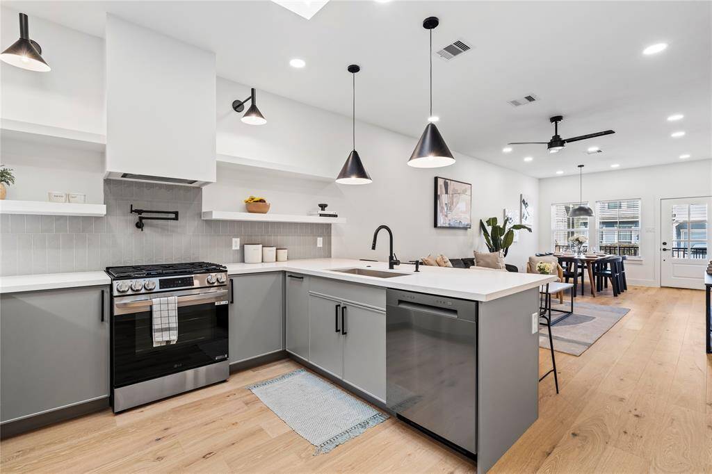 Stainless steel state of the art appliances with a sleek vent hood design with floating shelves.