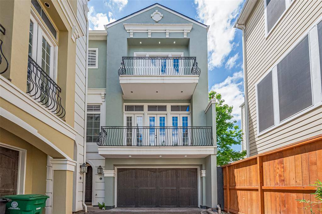 Impressive and architecturally elegant, the three-story façade is defined by stacked balconies and striking wooden garage doors. Clean lines and tall proportions set a sophisticated tone.