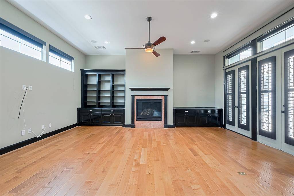 The heart of the home resides on the second level, where gleaming wood floors meet bold black trim. Open sightlines stretch across living, dining, and kitchen areas—creating a space as functional as it is beautiful.
