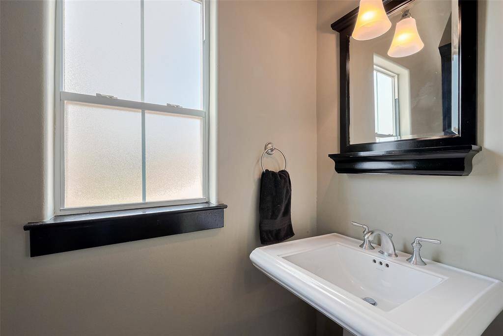 Bright and fresh, the powder room is enhanced by a frosted window, clean lines, and a well-proportioned vanity with mirror—offering both function and style.