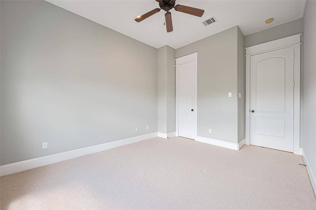 Upstairs, this tranquil bedroom features soft neutral tones, a ceiling fan, and abundant natural light—perfect for creating a serene personal retreat. Includes a private en suite.