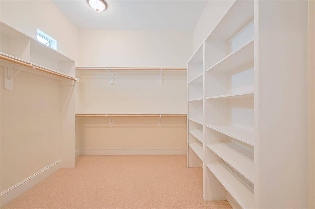 Tailored for both style and ease, the expansive closet includes built-in drawers, shelves, and ample hanging space—all set against plush carpeting for a boutique-style experience.