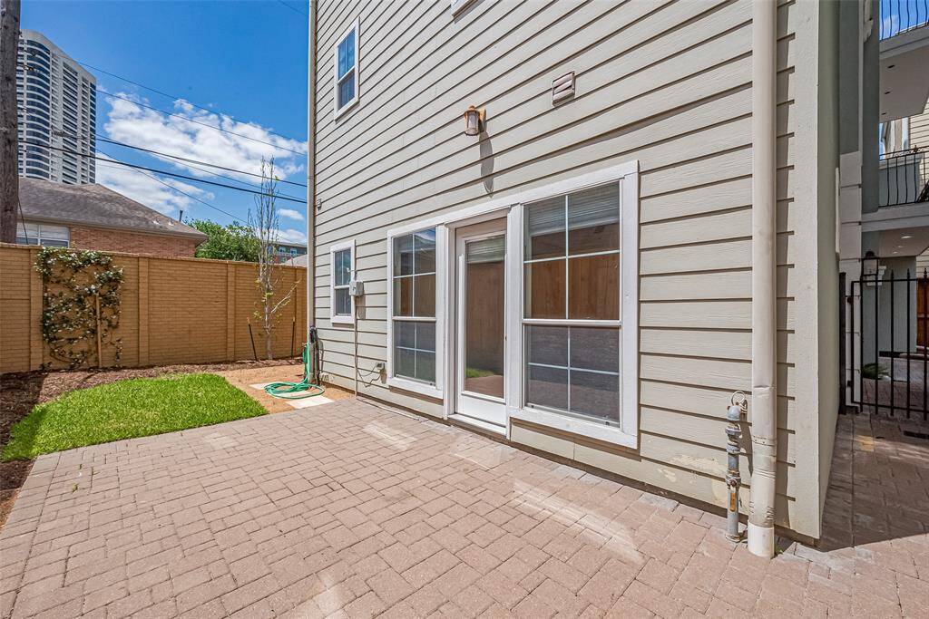 The open patio offers a generous canvas for outdoor dining or entertaining, with a grassy area nearby.