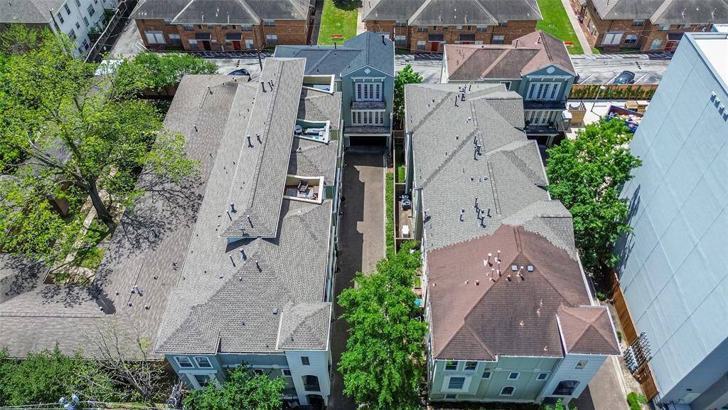 From above, the home reveals its striking three-story form nestled securely within a gated enclave. The tiered balconies and clean architectural lines stand out, offering privacy and presence in the heart of the city.