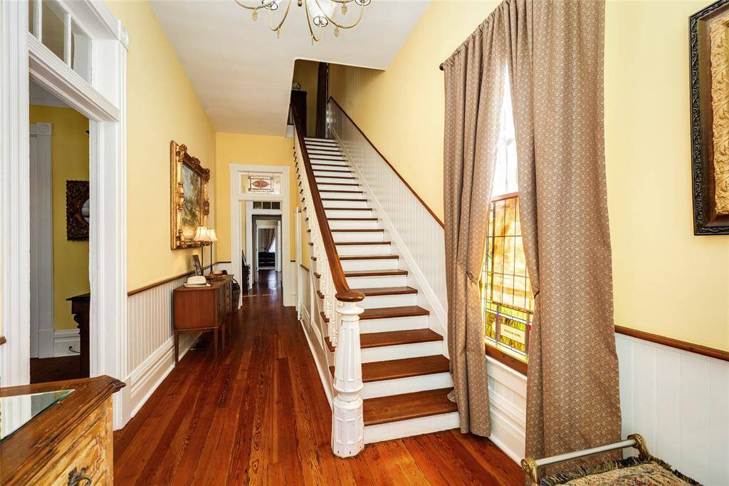 Staircase of foyer leading upper level.  Flowing foyer that flows to reading nook and back bedroom and living space.