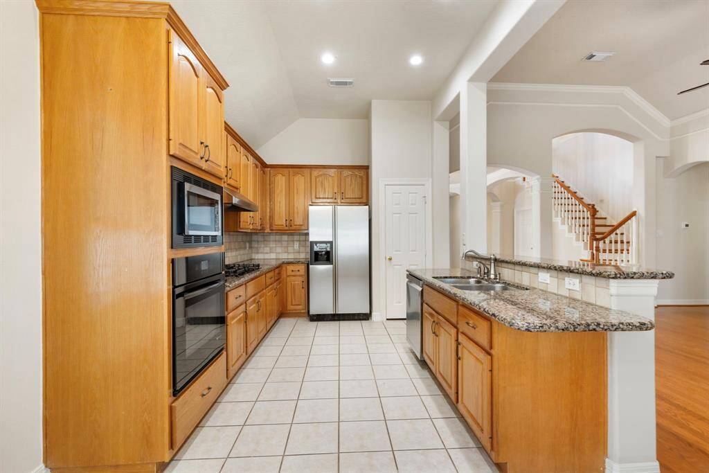 This kitchen comes complete with a gas cooktop, granite countertops, tons of cabinet space and bonus: the fridge stays!
