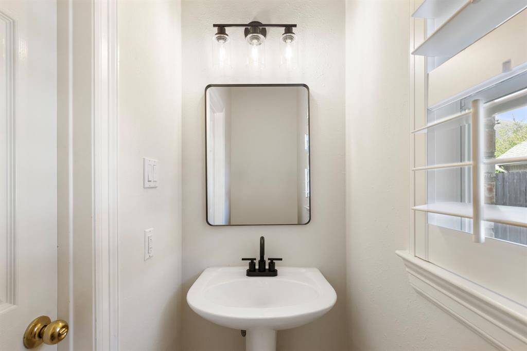Half bathroom on the 1st floor with updated mirror, light fixture and faucet.