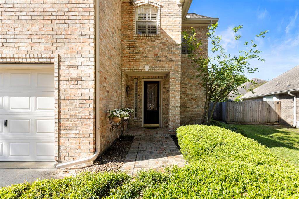 Nicely manicured brick walk-way leads to the covered front porch to welcome guests.