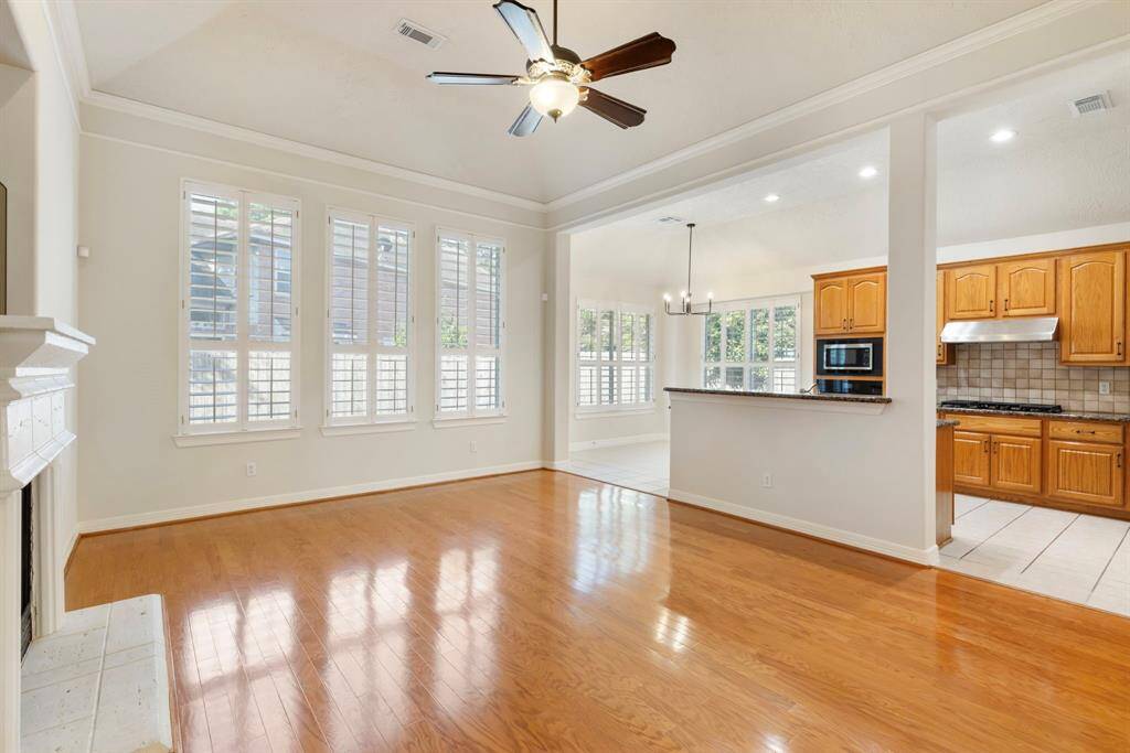 This space is flooded with natural light and highlighted by upgraded plantation shutters, hard surface flooring, high vaulted ceilings with crown moulding and more.