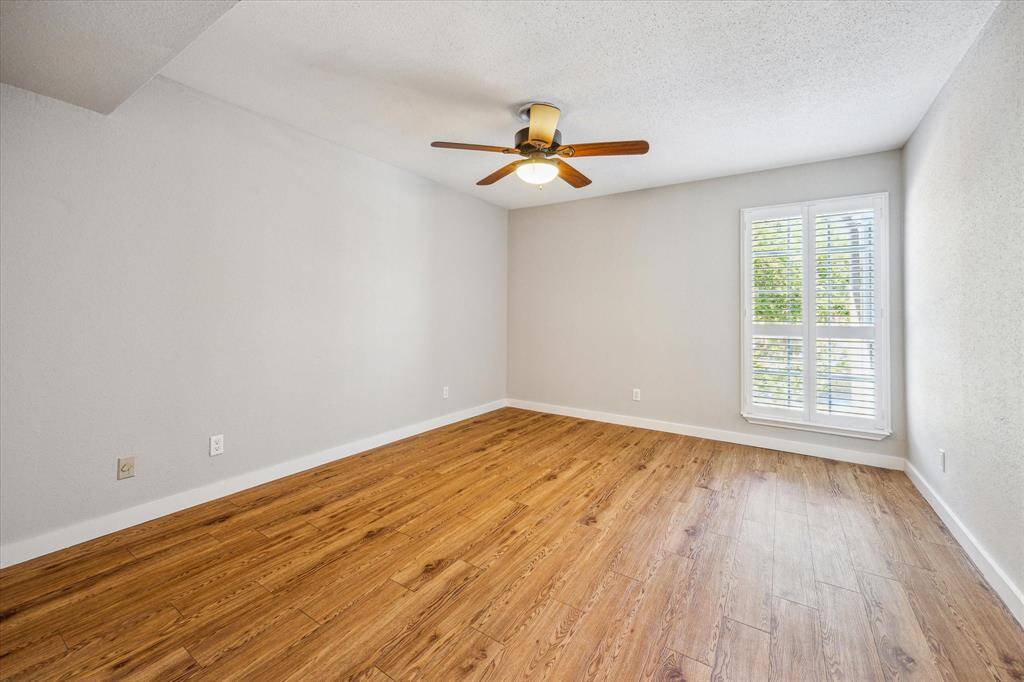 The spacious bedroom features a walk-in closet, ceiling fan and plantation shutters.