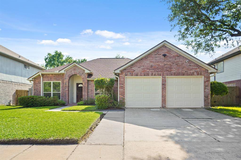 Charming brick home at 18818 Timber Way Dr. features a pristine yard and a spacious two-car garage.