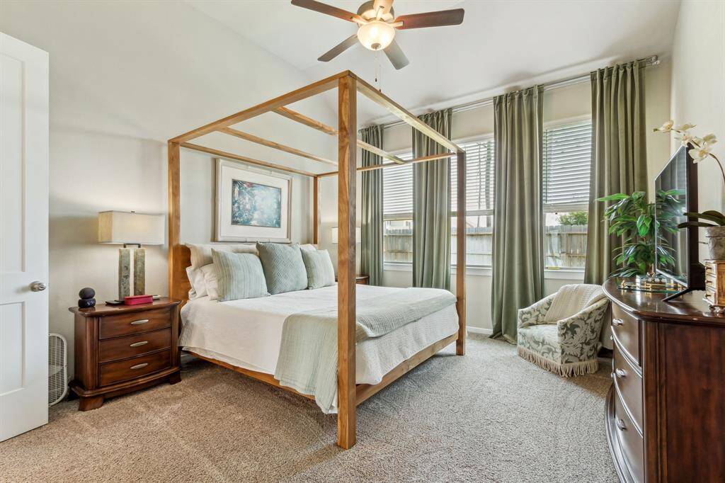 Primary Suite shown with a King Size poster bed, two night stands Dresser, chair, and oversized floor mirror