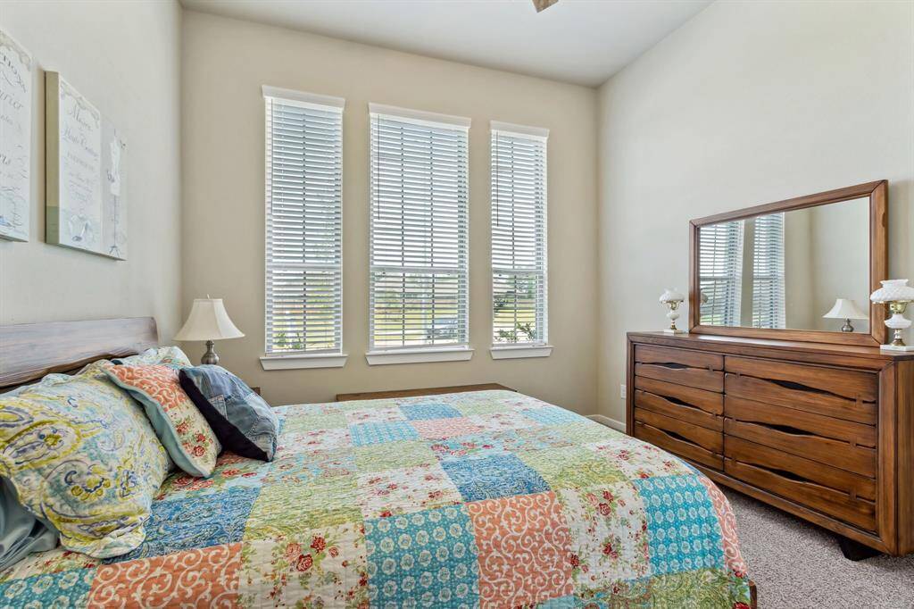 Guest bedroom 1 located on the front of the home has large windows for a cheery setting