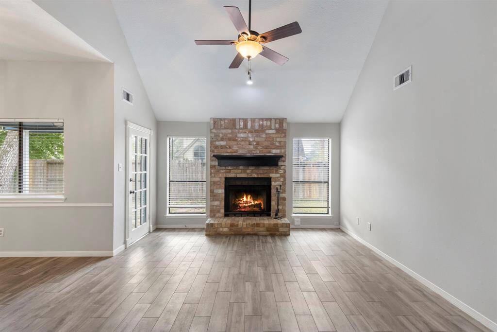 As you step through the front door, you're immediately greeted by the inviting warmth of the living room, where a cozy fireplace serves as the stunning focal point