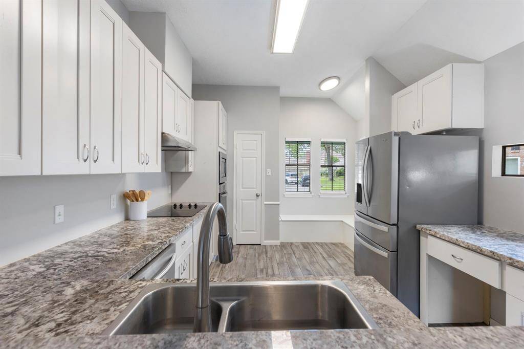 The dining room features a modern light fixture that illuminates the space, complemented by granite countertops with an overhang, perfect for bar stool seating