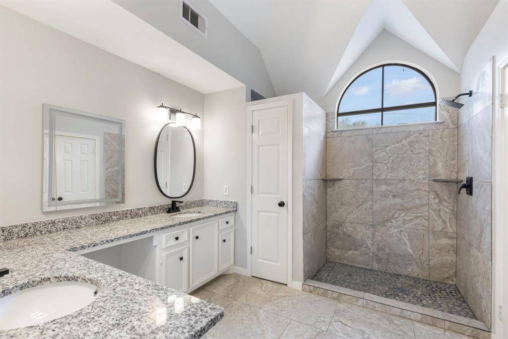 The expansive primary bedroom features vaulted ceilings, freshly painted walls, plush new carpet, and a ceiling fan for optimal comfort