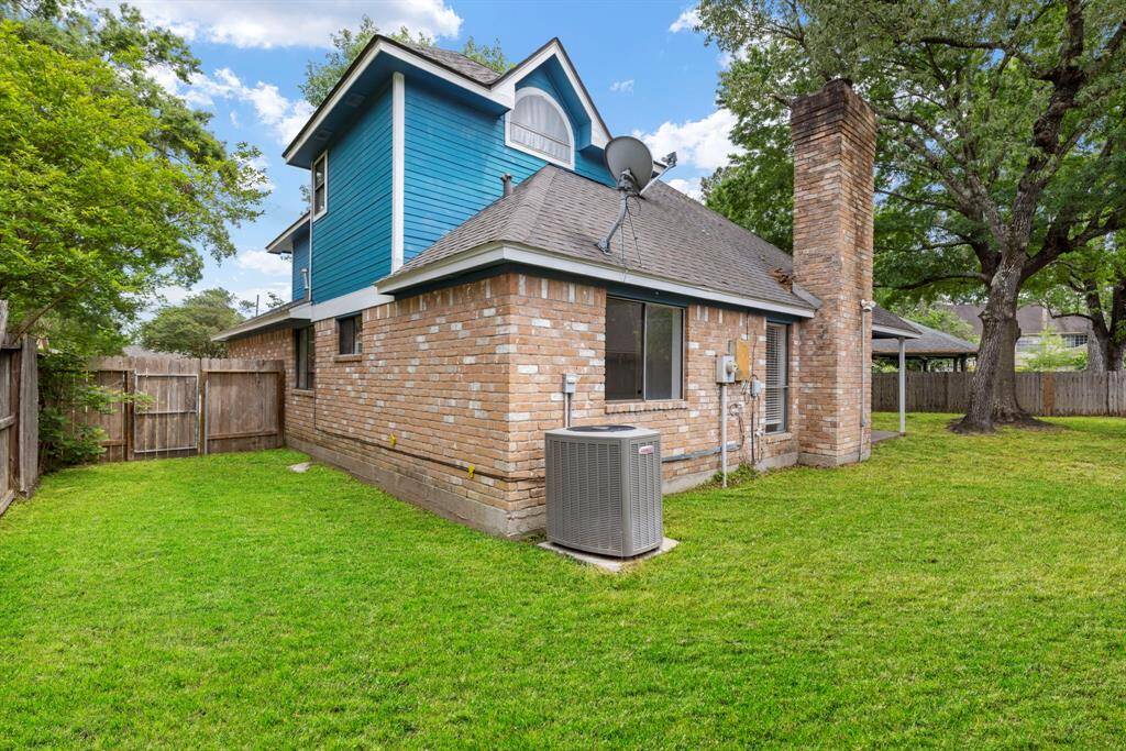 The backyard features a charming, covered patio perfect for relaxation, complemented by ample open space ideal for play and outdoor activities