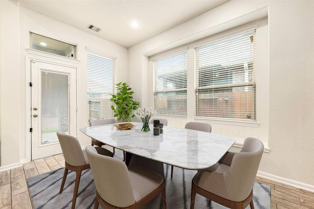 You and your guests will certainly dine in style in this amazing dining room! Featuring recessed lighting, large window with blinds and seating, neutral paint, high ceilings, and wood look tile flooring. Perfect space to entertain family and friends.