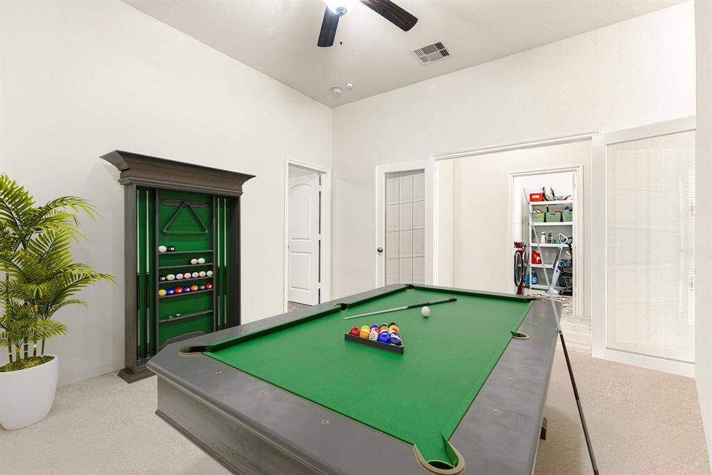 Perfect for entertaining is this amazing game room!  This space would be a fabulous teen hangout, media room, or adult game room complete with pool table and big screen TVs. Featuring plush carpet, high ceilings, dark stained ceiling fan, neutral paint and French doors.