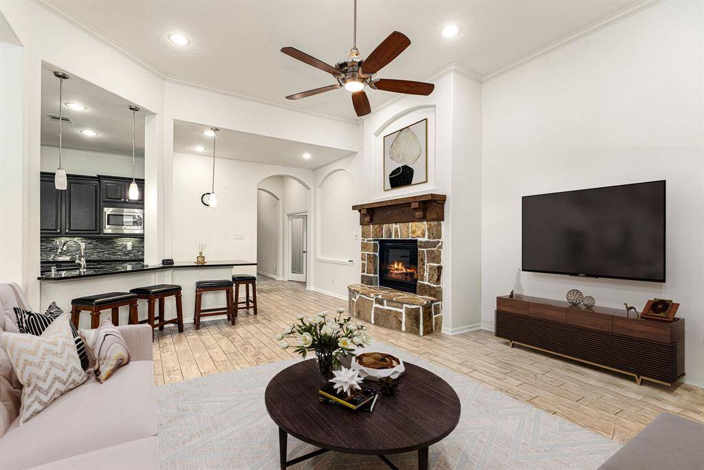 This light and bright spacious living room is the perfect layout for entertaining or just relaxing. Whether it's simply a night in or entertaining family and friends, this home has ample open space for everyone to enjoy! Featuring a modern ceiling fan, wood look tile flooring, large windows with blinds, soaring ceilings, recessed lighting with wonderful access to your gorgeous kitchen.