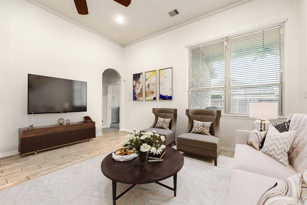 Gather the family and guests together in your lovely living room! Featuring soaring ceilings, recessed lighting, dark stained ceiling fan, neutral paint, gorgeous wood look tile floors and large windows that provide plenty of natural lighting throughout the day.