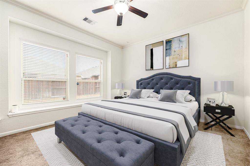 What a wonderful place to come home to, this stunning primary suite greets you with plush carpet, a warm neutral paint, high ceiling, crown molding, ceiling fan with lighting, lovely windows with blinds, allowing in natural light brightening up this spacious primary bedroom, with extra space for a seating area.