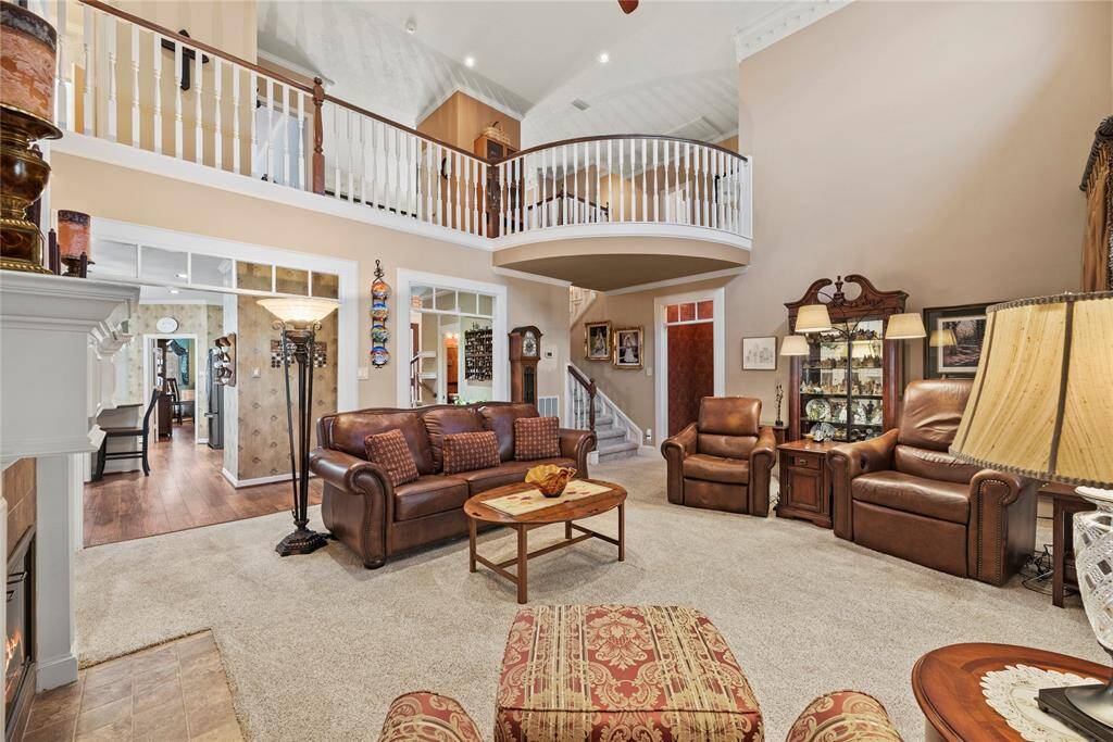 Alternate view of the living room from the backyard doors, showcasing the open-concept design. This angle highlights the staircase and second-floor balcony, seamlessly connecting both levels and enhancing the home's spacious feel.